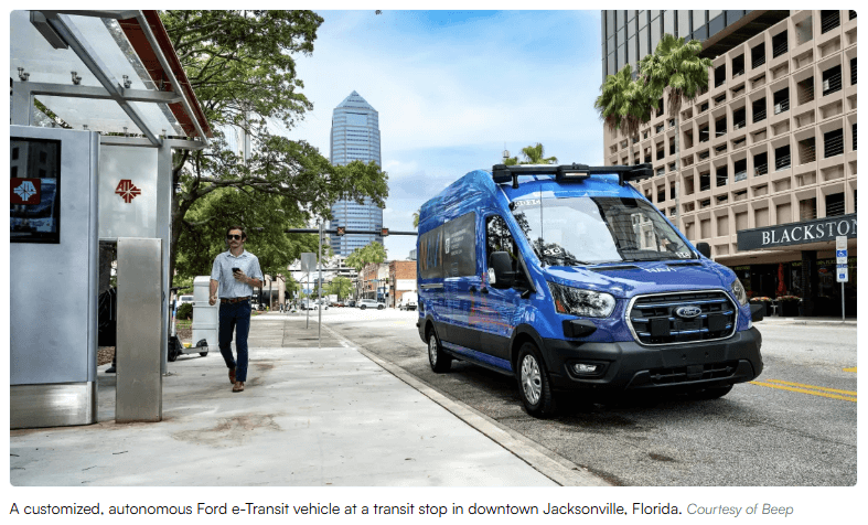 A customized, autonomous Ford e-Transit vehicle at a transit stop in downtown Jacksonville, Florida.