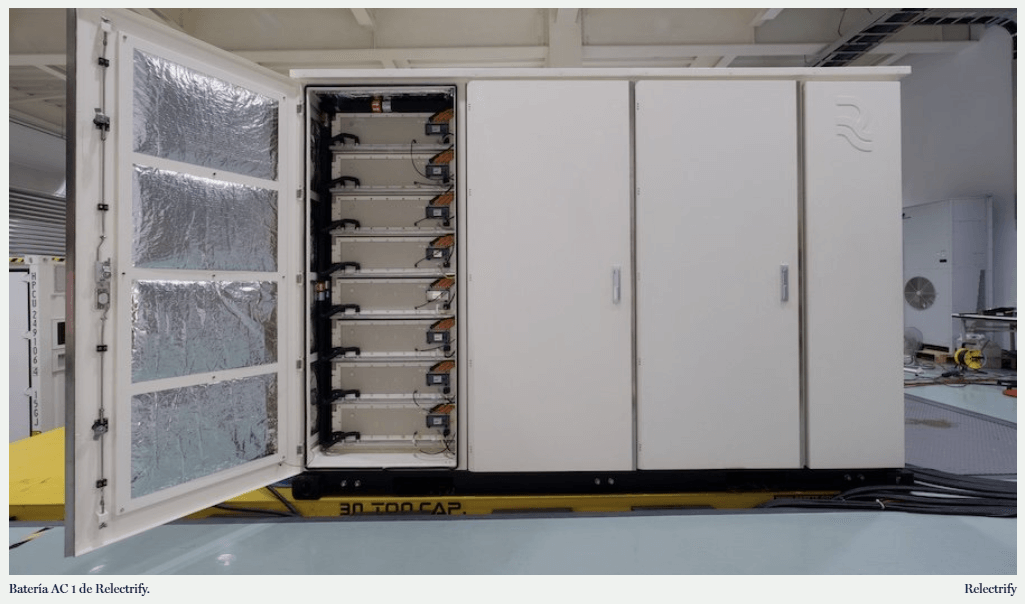 Rack de baterías con módulos y placas electrónicas visibles; cables conectados a un panel de distribución.