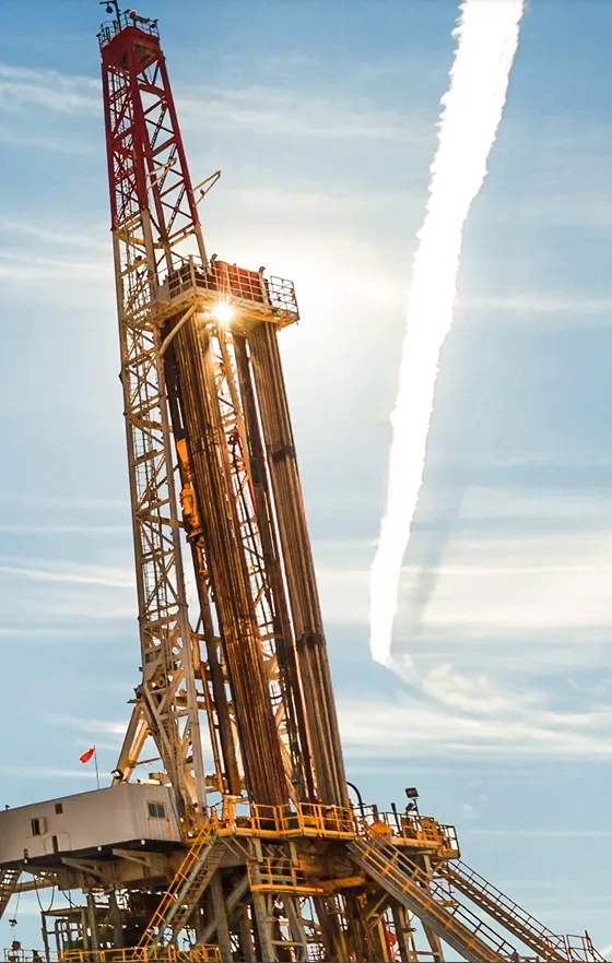 Esta imagen muestra una torre de perforación terrestre (comúnmente llamada rig), la pieza central de la infraestructura para extraer petróleo o gas natural.