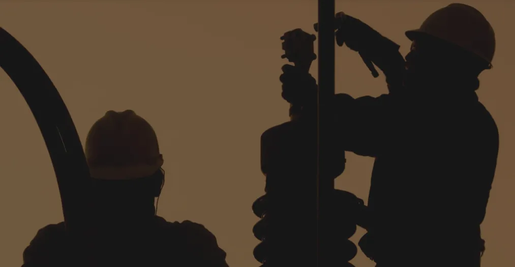 Se muestra un momento de trabajo industrial, específicamente a 2 trabajadores en una subestación de energía.