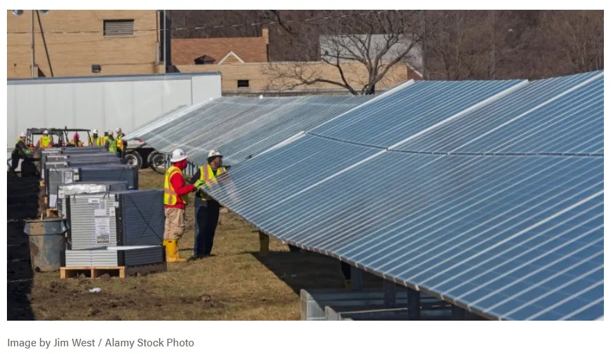 La imagen muestra la instalación de paneles solares en un campo abierto.
