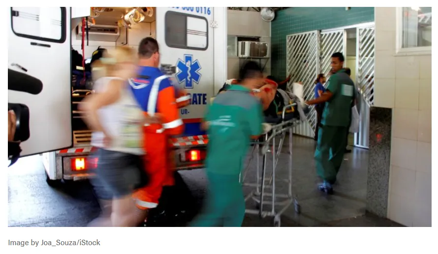 Se muestra el traslado de un paciente en camilla desde una ambulancia hacia un centro de salud.
