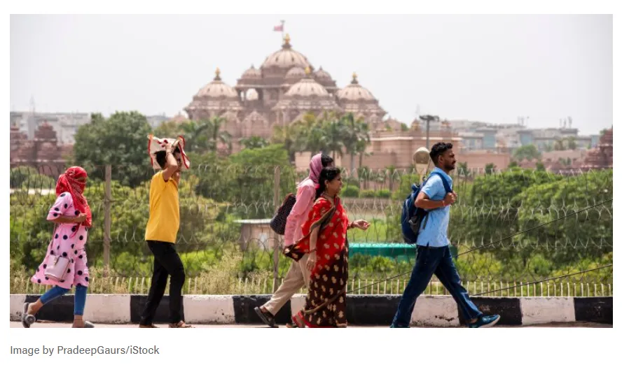 La imagen muestra a personas caminando frente al Templo Akshardham en Nueva Delhi, India, durante una ola de calor.