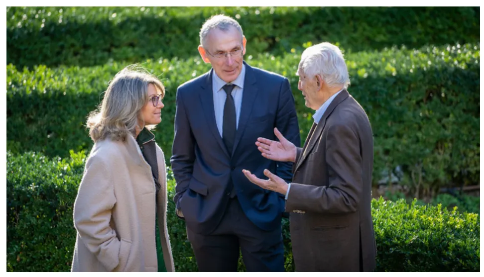 Esta imagen muestra a un grupo de personas conversando en un entorno al aire libre.