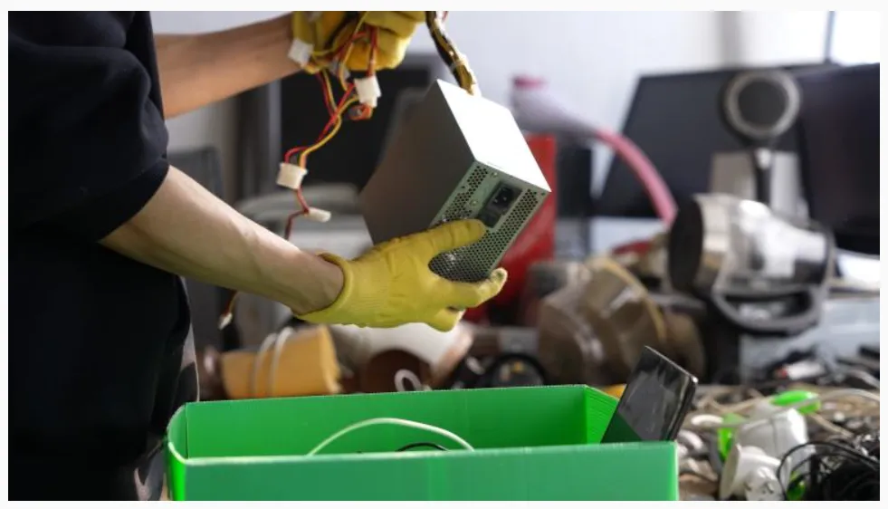 La imagen muestra el manejo de residuos electrónicos, comúnmente conocidos como e-waste, en un centro de reciclaje especializado.