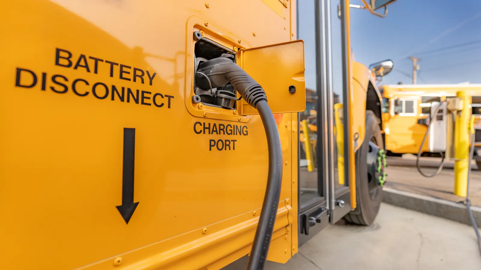 Autobuses escolares eléctricos conectados a cargadores bidireccionales.