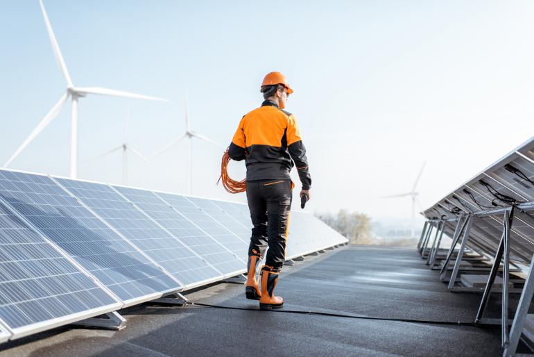 Operador en medio de un proyecto de energias renovables que incluye energía solar y eólica.