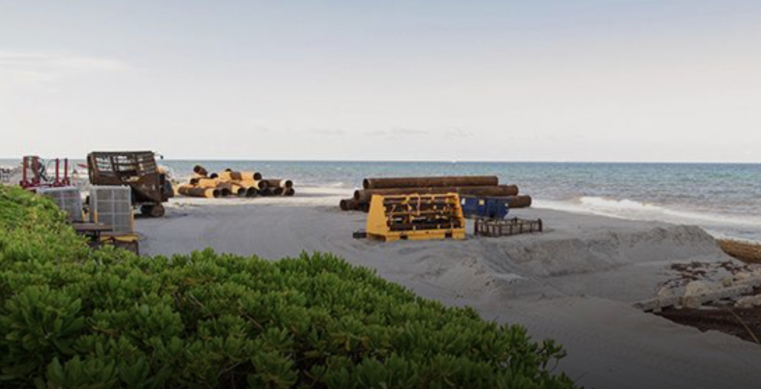 Zona de obra e infraestructura energética y resiliencia costera en una playa.